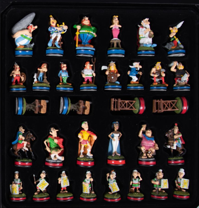 A set of painted Asterix character figurines — Asterix, Obelix, Getafix and others — arranged as two teams of chess pieces.